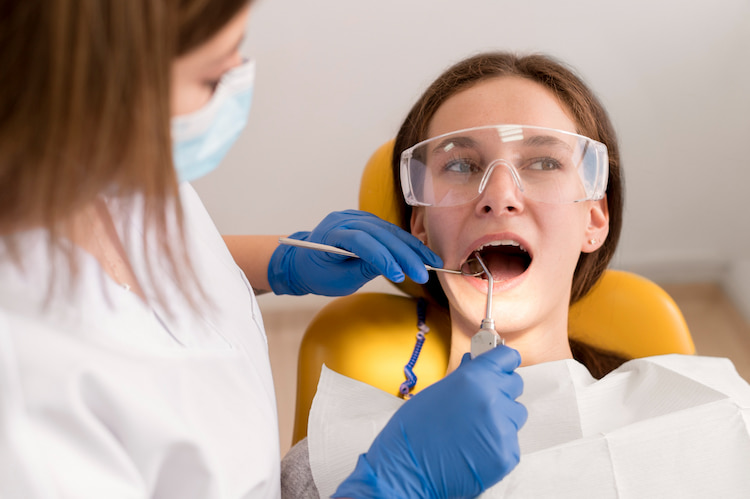 a dentist is checking a patient's gums to perform a gum treatment. 