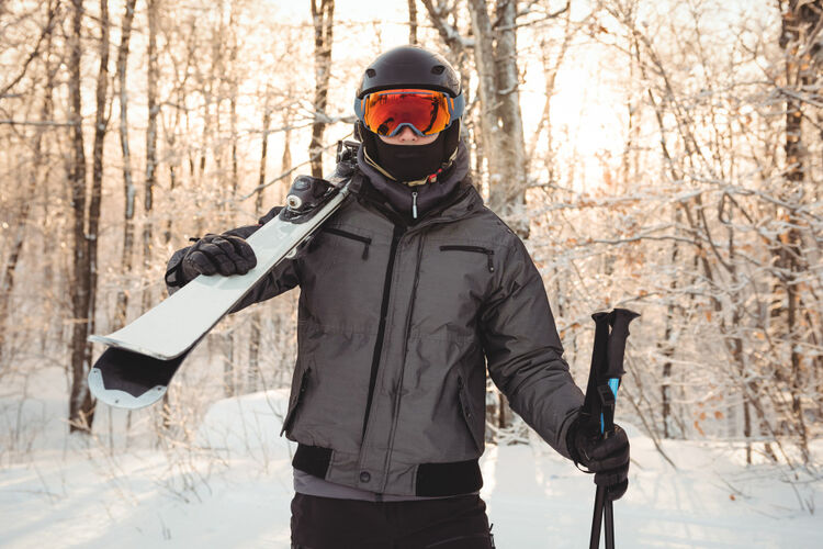 A fully geared male snowboarder wearing complete safety equipment, including helmet, mouthguard, goggles, and protective clothing.