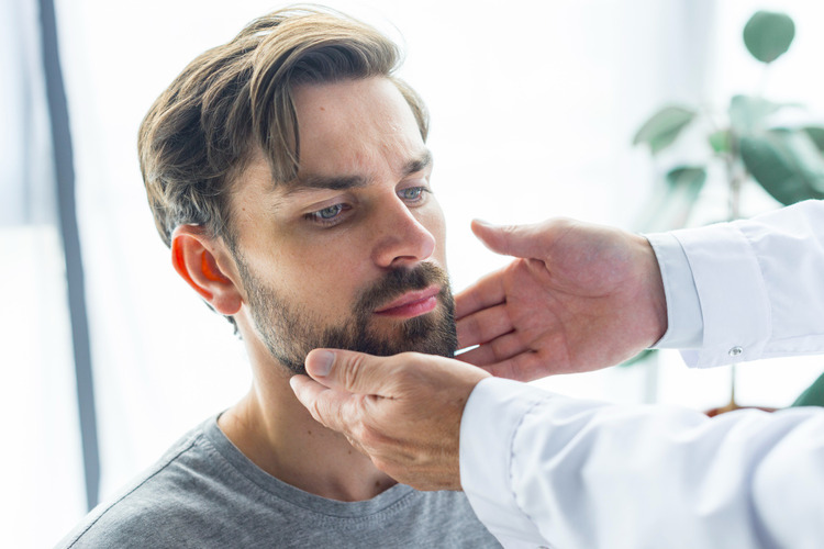 A man being examined by a dentist in a dental clinic for stress-related teeth grinding and jaw tremors