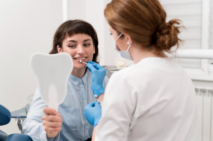 Young woman in a dental office being examined by a dentist to determine whether porcelain or composite veneers are the better option